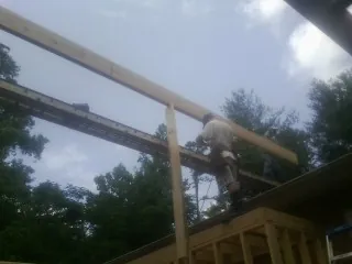 Carpenter setting a ridge beam over a new addition frame — Ice Dam Removal by Roofing Brothers in White Hall