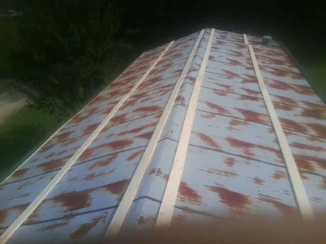 Rusted metal roof panels with new wood purlins before replacement — Storm Damage Roof Repair in White Hall by Roofing Brothers